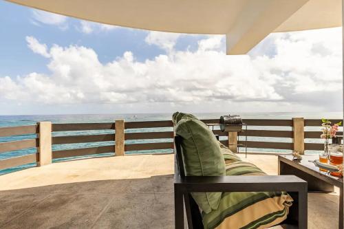 a couch sitting on a balcony looking out at the ocean at Water Lovers Paradise! in Ocho Rios