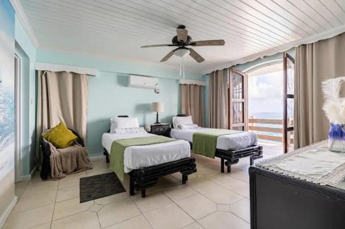 a bedroom with two beds and a ceiling fan at Water Lovers Paradise! in Ocho Rios