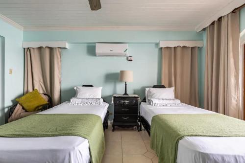 two beds in a room with blue walls at Water Lovers Paradise! in Ocho Rios