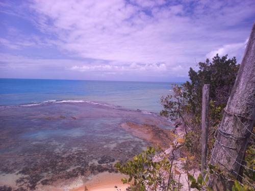 vista su una spiaggia con oceano e recinzione di Pousada Imperador do Espelho a Praia do Espelho