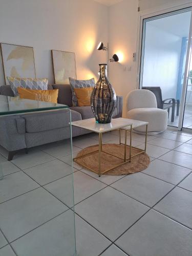 a living room with a couch and a table at Ste Luce, N° 11 Appart -300m Plage de Mabouyas in Corps de Garde