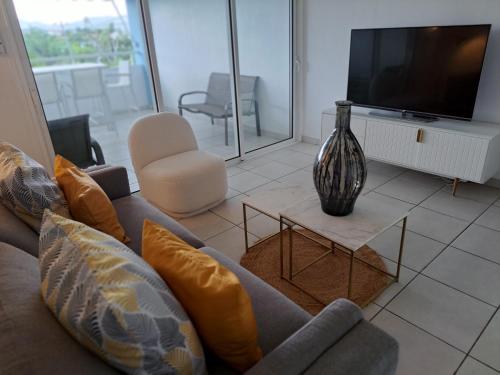 a living room with a couch and a vase on a table at Ste Luce, N° 11 Appart -300m Plage de Mabouyas in Corps de Garde