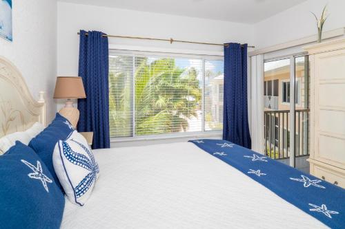 a bedroom with a bed and a large window at Kaibo Sunset Condo in Driftwood Village