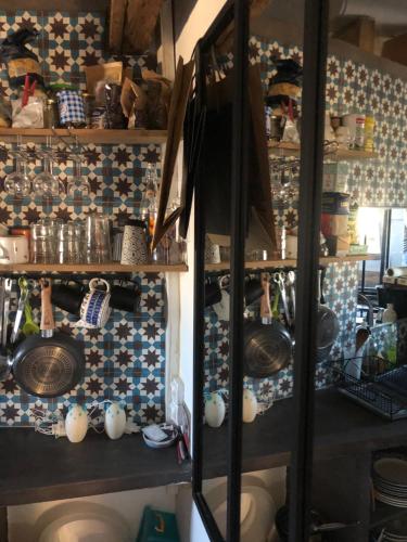 - une cuisine avec un bouquet de vaisselle sur les étagères dans l'établissement STUDIO sous les toits de PARIS GRANDS BOULEVARDS, à Paris