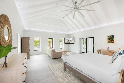 The Mastic Cana Luxury Cottage في North Side: غرفة نوم بيضاء مع سرير وأريكة