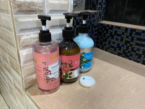 three bottles of soap sitting on a counter in a bathroom at Suria 3 Sepang with private pool in Sungai Pelik