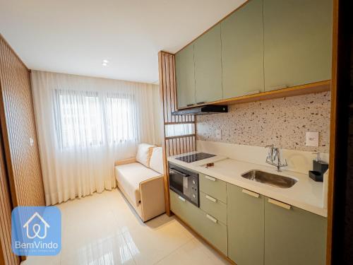 uma pequena cozinha com armários verdes e um lavatório em Apartamento de alto padrão no Caminho das Arvores em Salvador