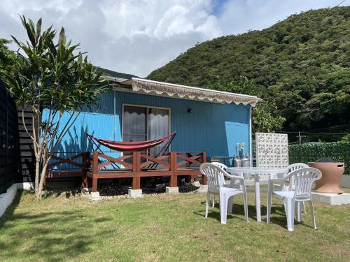 a blue house with a hammock and a table and chairs at Koniyado Room 103 - Vacation STAY 42437v in Setouchi
