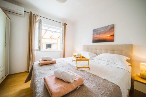 a bedroom with a large bed with two towels on it at Apartman Marta in Zavalatica