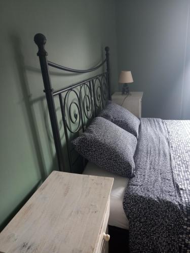 a bedroom with a bed and a wooden table at Li Pitite Magrite in Manhay