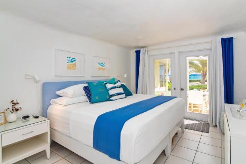 a bedroom with a large bed with blue and white pillows at Sea Biscuit at The Sea Lodges in Driftwood Village