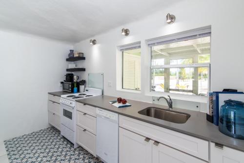 a kitchen with white cabinets and a sink at Sea Biscuit at The Sea Lodges in Driftwood Village