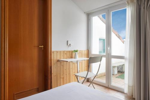 een kamer met een bed, een stoel en een raam bij Leizarooms in Leitza