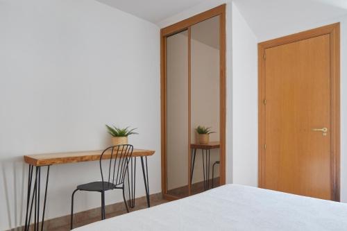 a bedroom with a bed and a table and a chair at Leizarooms in Leitza