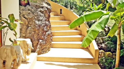 a set of stairs with a stone wall at Soleil D'asie Residence in Chaweng Noi Beach