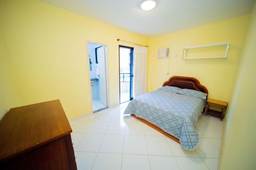 um quarto com uma cama no canto de um quarto em Joao Meira Apartments em Guarapari