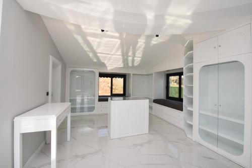 um quarto branco com uma mesa branca e 2 janelas em Luxus Villa Kargicak em Kargicak