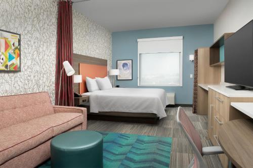 a hotel room with a bed and a couch at Home2 Suites By Hilton Miami Doral West Airport, Fl in Miami