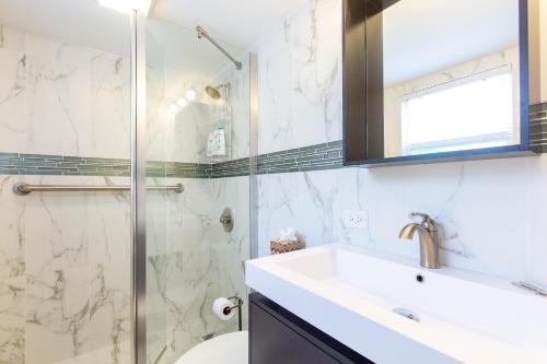a bathroom with a sink and a glass shower at Cocoplum #1 Condo in George Town