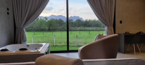 a room with a bath tub and a large window at Refúgio da Mata in Morretes