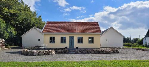 a small white house with a red roof at Mysigt hus i liten by nära havet in Ystad