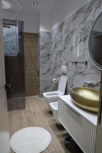 a bathroom with a toilet and a sink and a shower at Noel City Centre Apartment in Berat