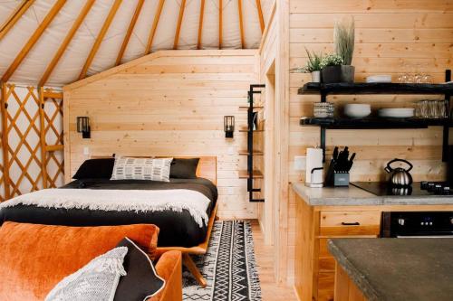 ein Schlafzimmer mit einem Bett in einer Holzhütte in der Unterkunft Santeetlah @ Sky Ridge Yurts in Bryson City