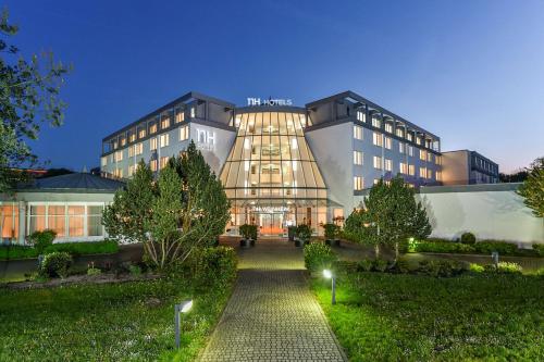 a hotel building with a walkway in front of it at NH Weinheim in Weinheim