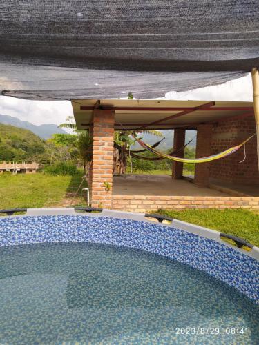 a swimming pool in front of a house at Altos del Reposo Casa Campestre in Pueblo Bello