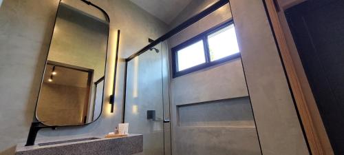a bathroom with a door with a mirror and a window at Refúgio da Mata in Morretes