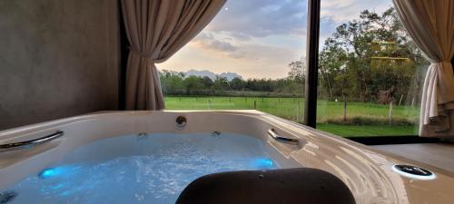 a jacuzzi tub with a view of a field at Refúgio da Mata in Morretes