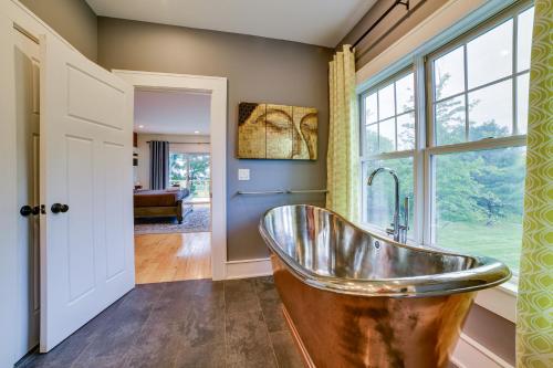 a bath tub in a bathroom with a window at Secluded Home with Hot Tub about 5 Mi to Cornell! in Ithaca
