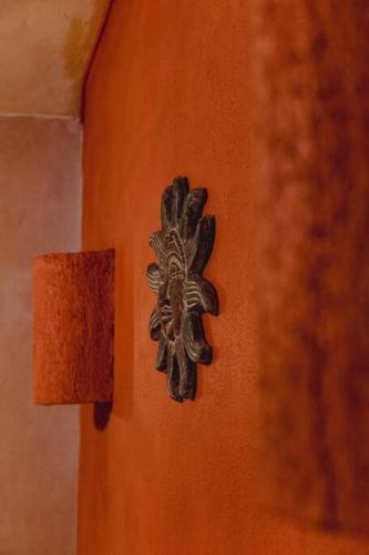 a orange wall with a metal object on it at Casabu in Zihuatanejo