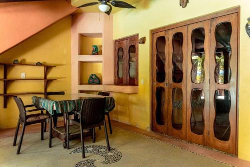 a room with a table and a cabinet with vases at Casabu in Zihuatanejo