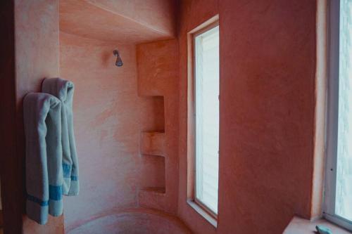 a bathroom with a window and a shower with towels at Casabu in Zihuatanejo