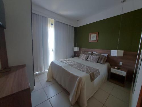 1 dormitorio con cama y pared verde en Aldeia das Aguas Quartier en Barra do Piraí