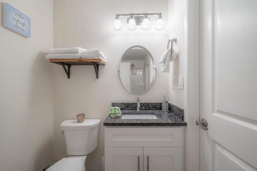 a white bathroom with a sink and a mirror at Seminole Heights - Foodie Capital of Tampa in Tampa