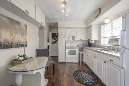 a kitchen with white cabinets and a glass table at Seminole Heights - Foodie Capital of Tampa in Tampa