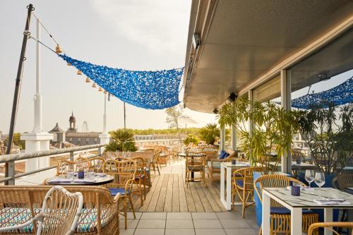 a balcony of a restaurant with tables and chairs at Hotel Indigo Bordeaux Centre Chartrons by IHG in Bordeaux