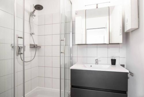 een witte badkamer met een wastafel en een douche bij Black&Yellow Designer Apartment Bielefeld in Bielefeld