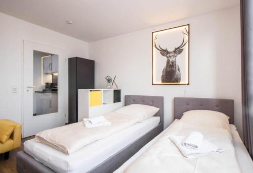 twee bedden in een kamer met een foto van een hert aan de muur bij Black&Yellow Designer Apartment Bielefeld in Bielefeld