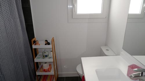 a bathroom with a sink and a toilet and a window at Casa nueva a pie de la Sierra de Guadarrama in Moralzarzal