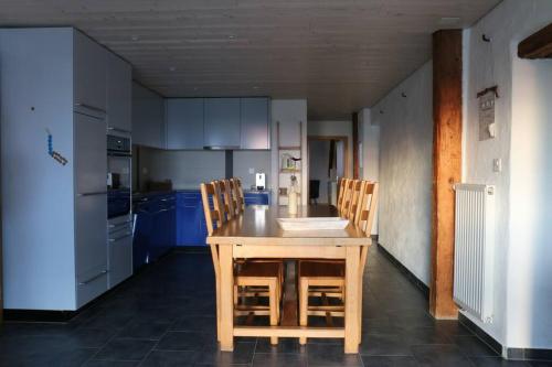 een keuken met een houten tafel en stoelen bij Appartement de vacances in Saulcy