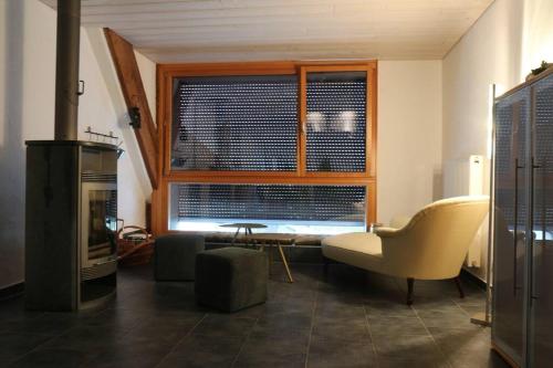 a living room with a chair and a window at Appartement de vacances in Saulcy