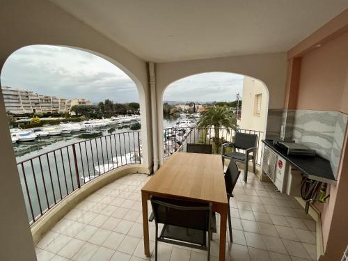 a balcony with a table and a view of a harbor at Studio moderne - Port de Mandelieu - Proche Mer in Mandelieu-la-Napoule
