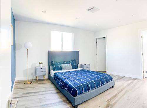 1 dormitorio con 1 cama azul y paredes blancas en Spacious Townhouse in Mid City - CR4-WIN, en Los Ángeles