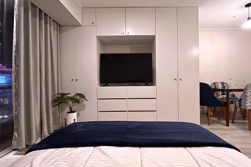 Schlafzimmer mit einem Bett und einem Schrank mit einem TV in der Unterkunft Loft céntrico San borja - San Isidro in Lima