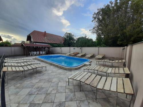 un patio con sillas, una piscina y una valla en 22 féröhelyes apartman en Balatonlelle