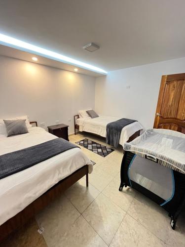 Zimmer mit 3 Betten in einem Zimmer in der Unterkunft Suite Los Sauces in Ibarra