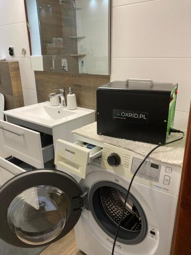 a washing machine in a bathroom with a sink at Apartament MATI in Wisła